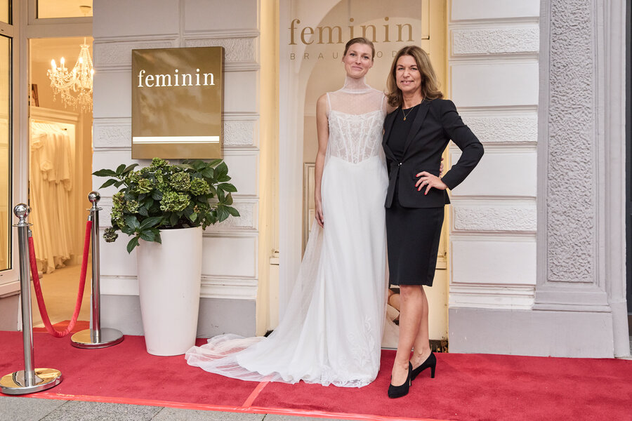 Inhaberin Beate Prohn mit Model in einem schönen Brautkleid auf dem roten Teppich